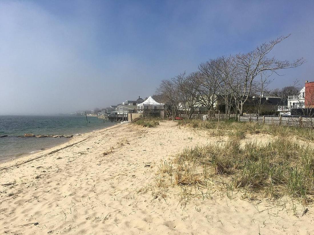 A foggy Provincetown beach with the town in the distance